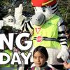 Photo of Zeal the Safety Zebra (a human wearing a zebra mascot costume) walking with a crowd of children